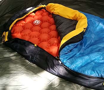 An image of fire orange color EcoTek Outdoors Hybern8 inside a sleeping bag.