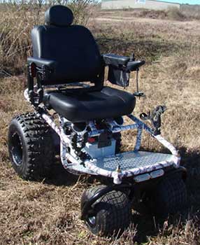 Outdoor Extreme Mobility Nomad All Terrain Power Wheelchair facing right on dry grass