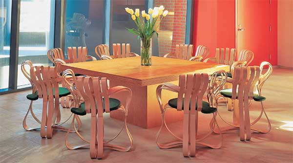 Gehry Cross Check Chair Set featuring 8 chairs made with ribbons of wood set around a wooden square table