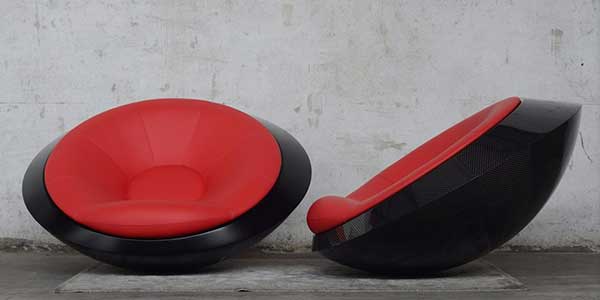 A UFO-like chair with spherical black bottom and red beanbag-like cushion