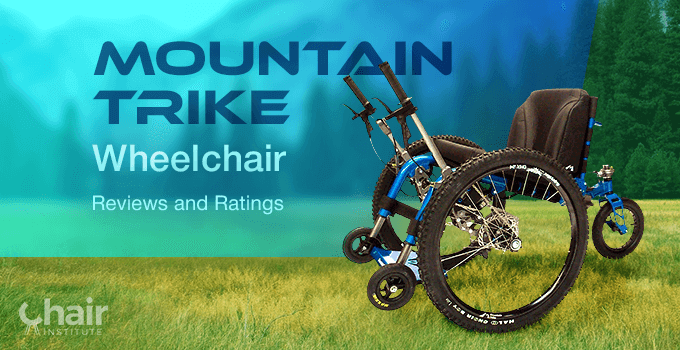 The Mountain Trike Wheelchair parked on grass and pine trees on the background