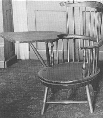 A black and white image of Thomas Jefferson's Swivel Chair made of wood, with a wooden writing arm