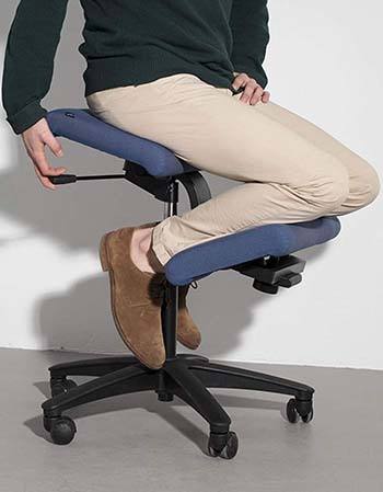 An image of man sitting in a Varier Wing Balans Chair in Blue color