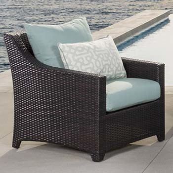 A club chair of the RST Brands Deco 8-Piece Patio Furniture Set with bliss blue padding 