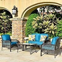 An outdoor setup of Ovios 4 Piece Rattan Furniture Set with blue cushions