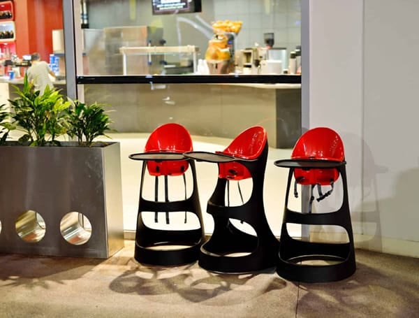 Three black and red baby chairs outside a restaurant
